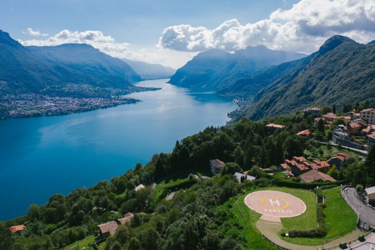 A breathtaking aerial view of Lake Como surrounded by lush green mountains and a quaint town.