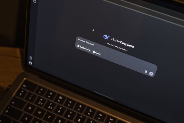 A laptop on a wooden table shows an AI chat interface, featuring the DeepSeek chatbot in action.